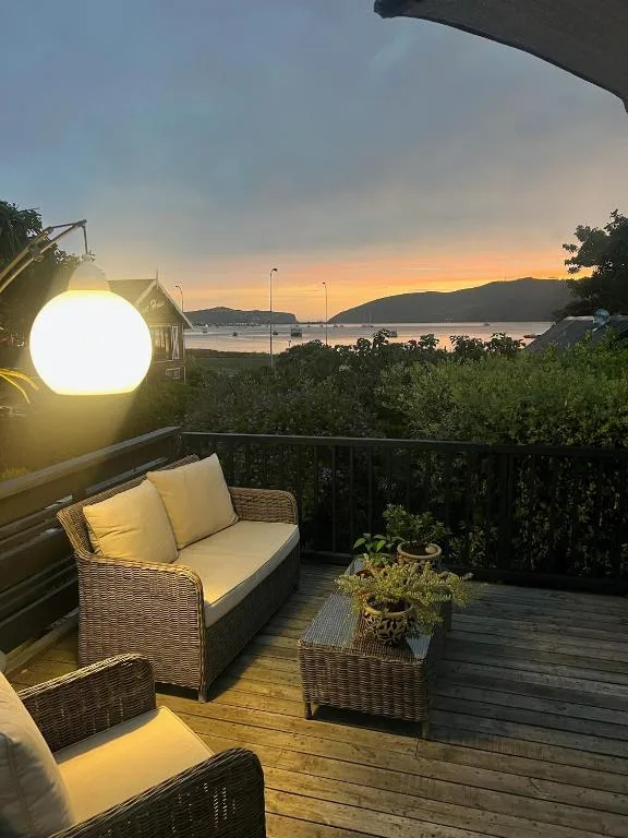 Outdoor deck at sunset with wicker seating overlooking Knysna Lagoon