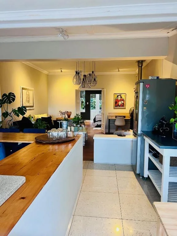 Bright yellow kitchen with wooden countertop, blue refrigerator, and pendant lighting