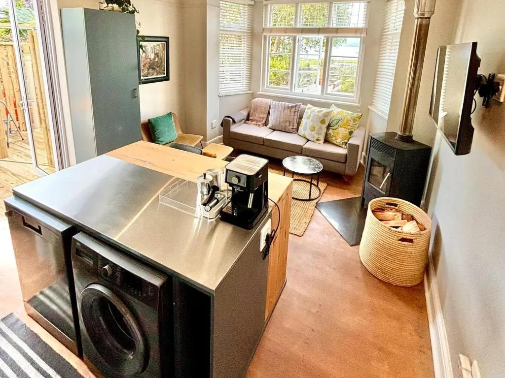 Modern open-plan kitchen with stainless steel island and lounge area visible
