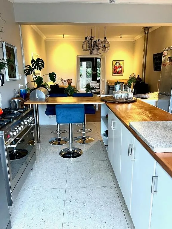 Modern kitchen with wooden counters, stove, and island seating area
