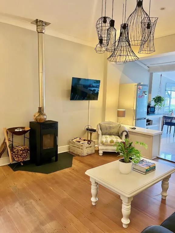 Spacious lounge with fireplace, TV, coffee table and designer pendant lights