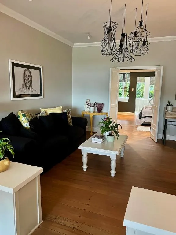 Spacious lounge with black sofa, white coffee table, and decorative pendant lights