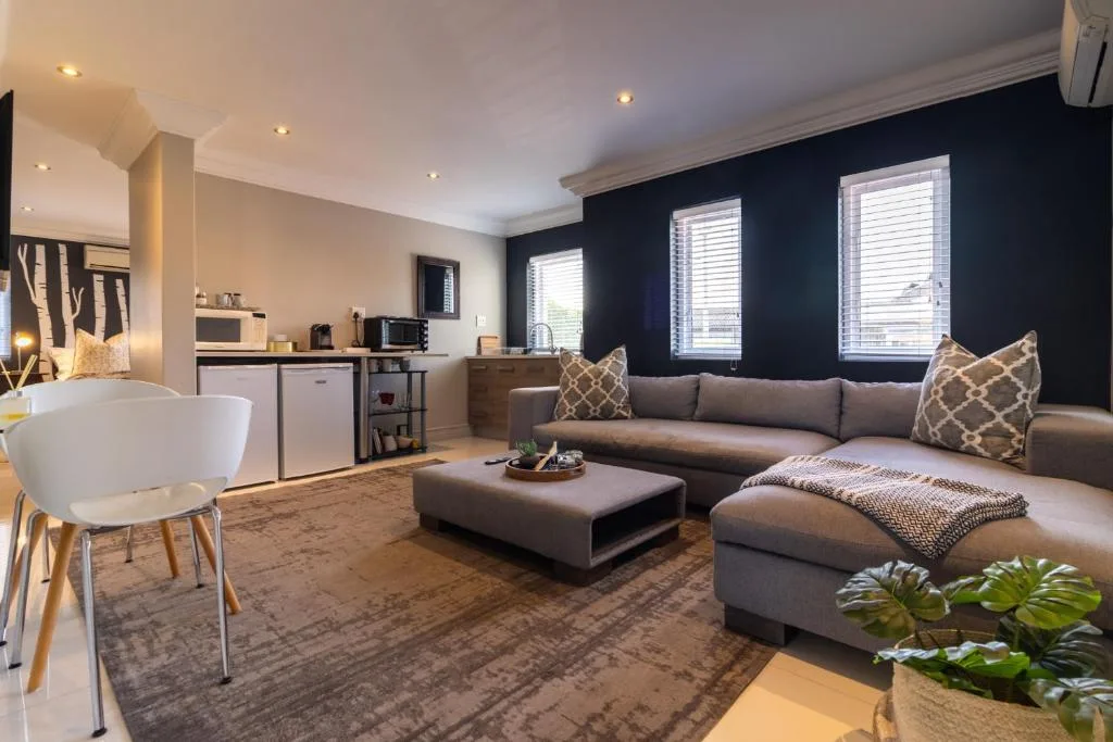 Modern open-plan lounge with gray L-shaped sofa and dark accent wall