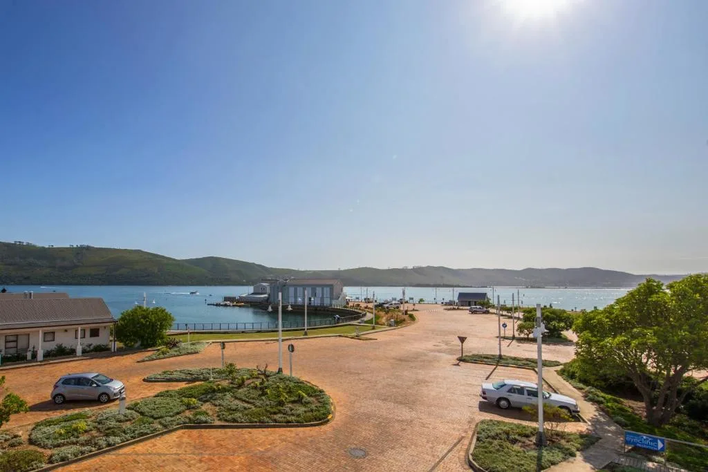 Scenic waterfront view of Knysna Harbour with blue water and surrounding green hills