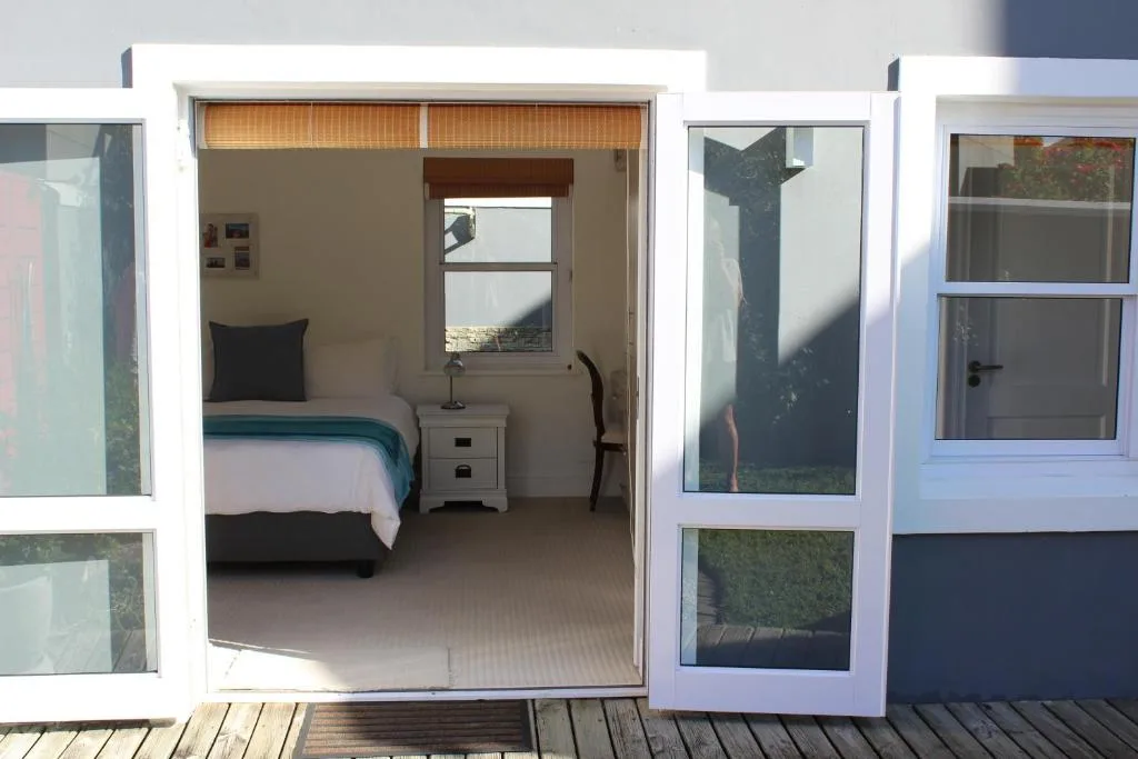 Bright bedroom with single bed, bedside table, and canal view window