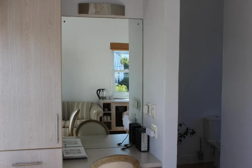 Bathroom vanity with mirror, kettle, and coastal view through window