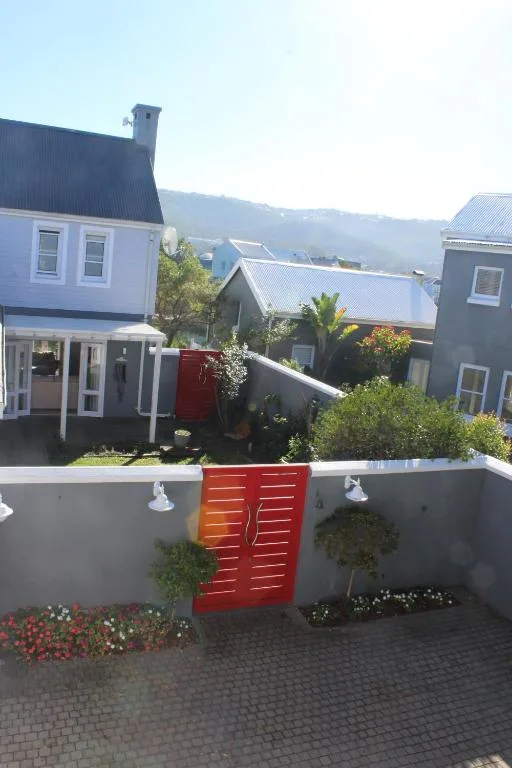 White house with red gate and garden entrance in Knysna