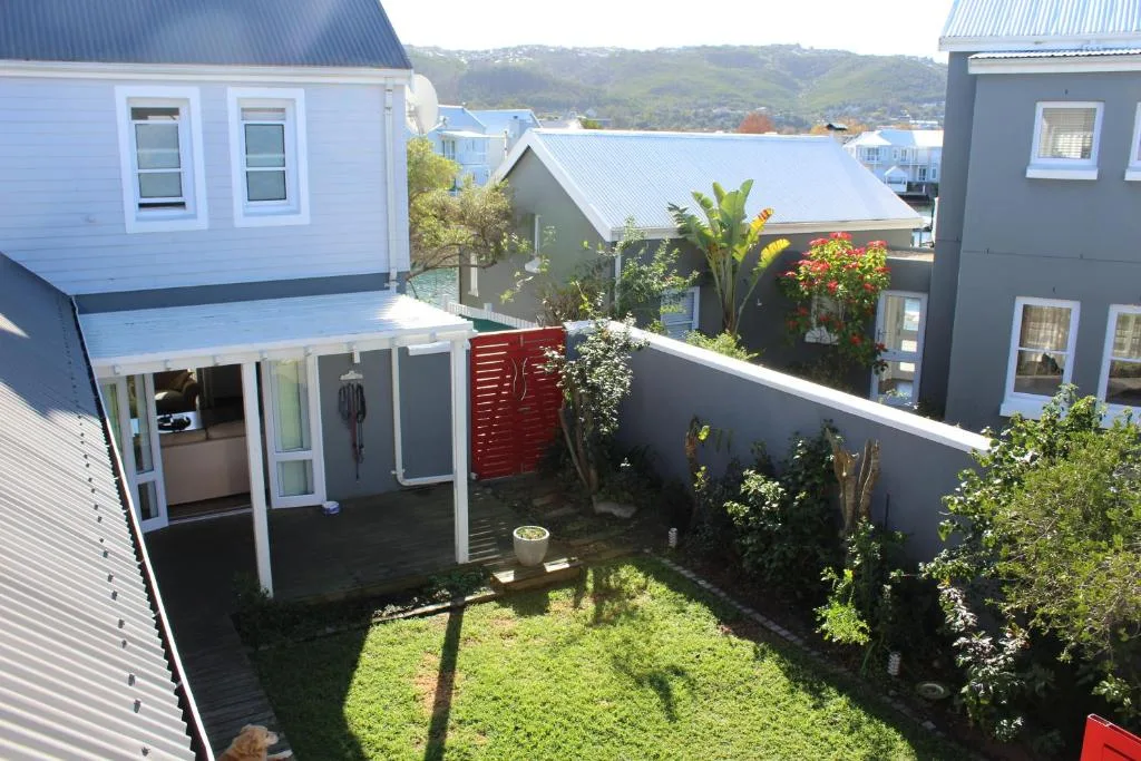 Modern white cottage with covered deck and private garden overlooking Knysna waterfront
