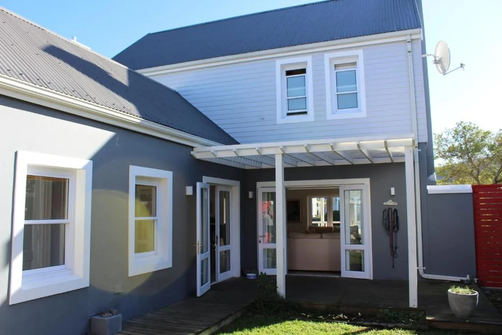 Modern two-story house with dark and light blue facade and covered patio entrance
