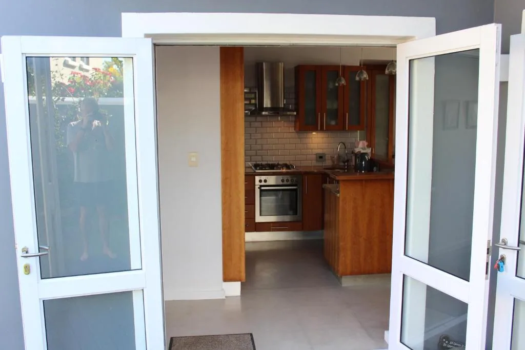 Modern kitchen with wooden cabinetry, stove, and brick backsplash viewed from doorway