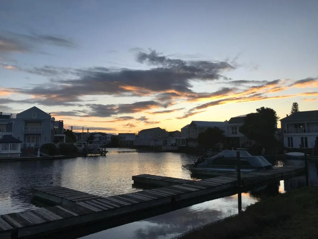 Sunset over Knysna lagoon with waterfront homes and wooden jetties