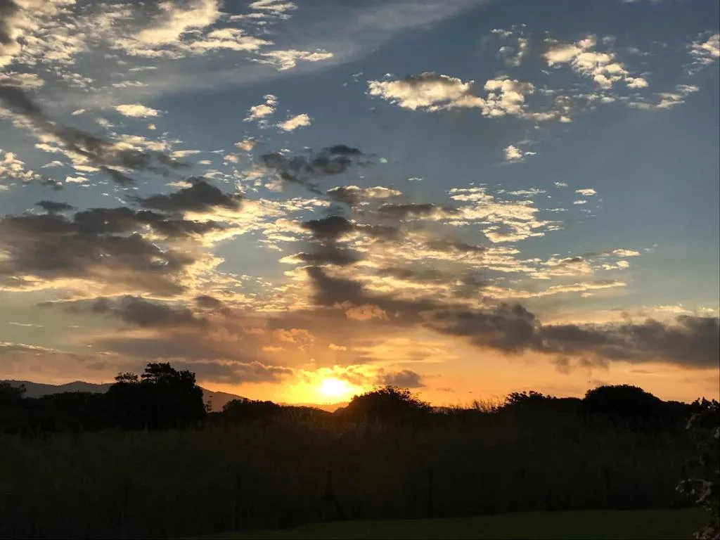 Dramatic sunset sky over mountains and countryside landscape