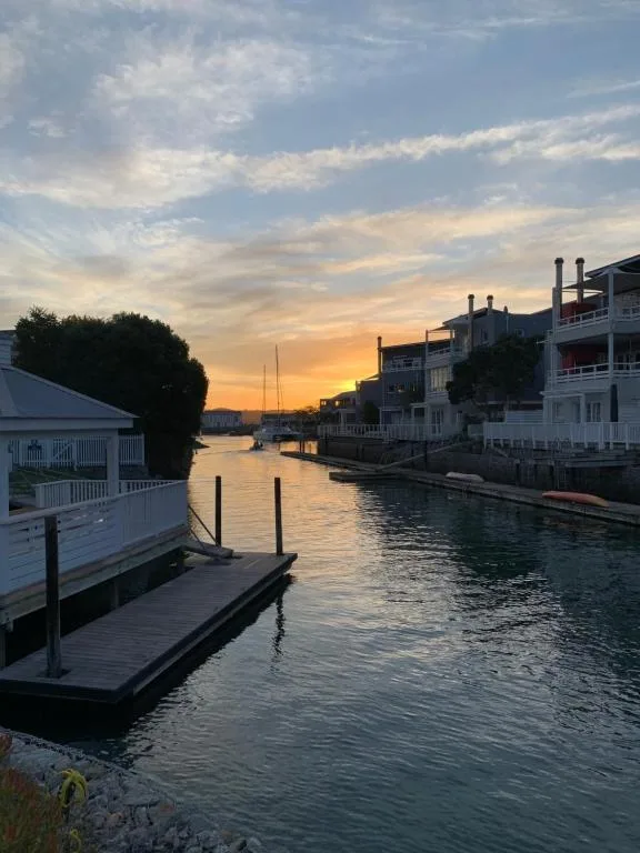 Sunset over Knysna lagoon with waterfront homes and boats
