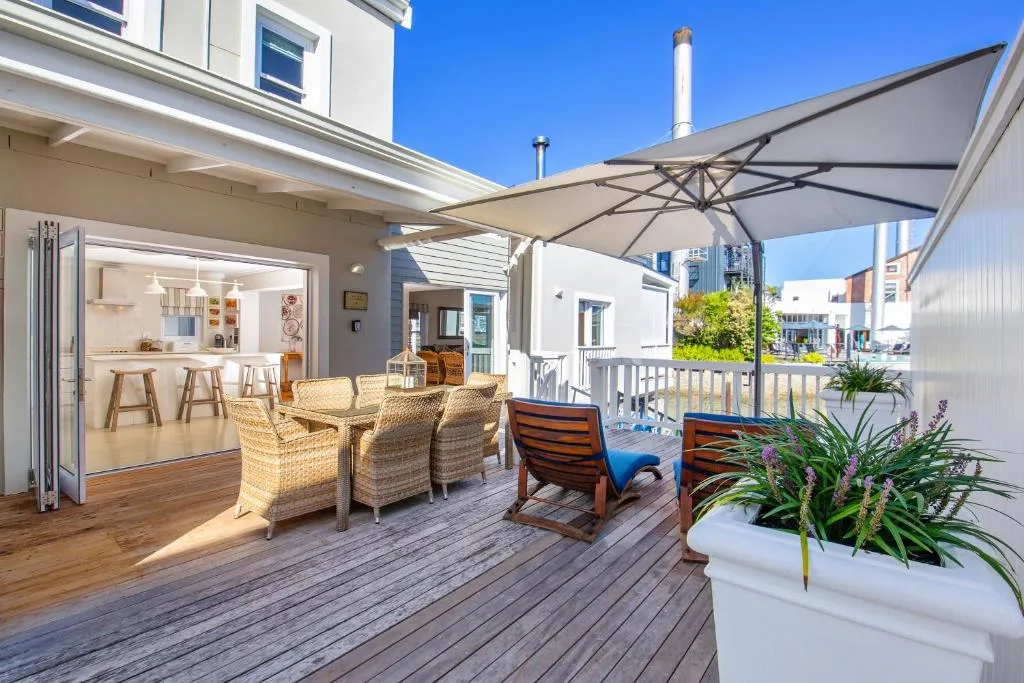Spacious outdoor deck with comfortable seating, umbrella, and coastal views