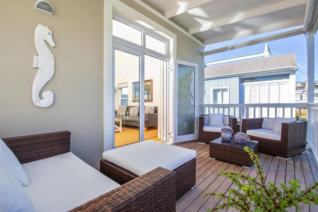 Wooden deck with rattan seating, white seahorse decor, and ocean views