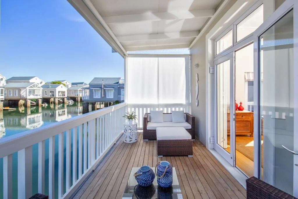 Waterfront deck with seating, white railings, and lagoon views