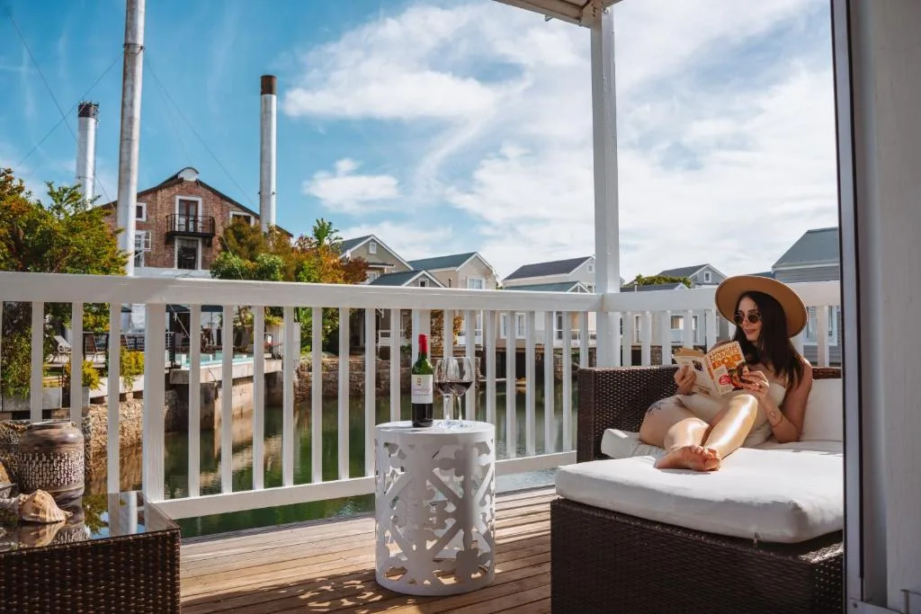 Covered deck with lounge seating overlooking waterfront neighborhood views