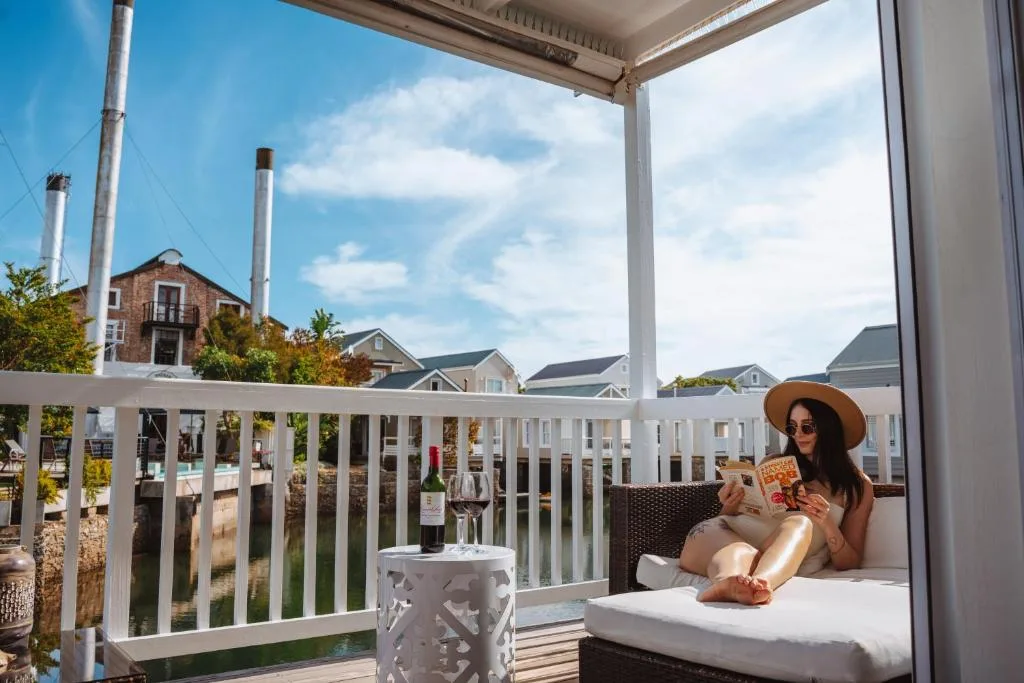 Woman relaxing on covered deck with water views and neighboring houses