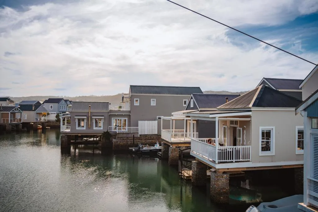 Waterfront holiday homes with white railings overlooking Knysna lagoon