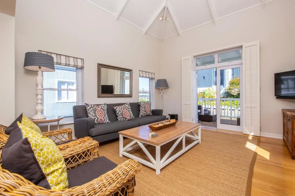 Spacious living room with sofa, wicker chairs, and sliding doors to deck