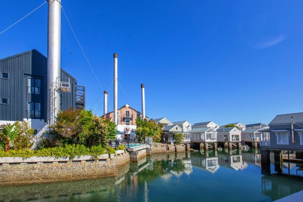 Waterfront view of Thesen Island with historic buildings and calm lagoon