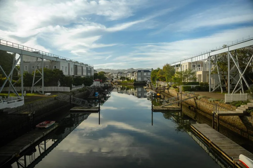 Scenic waterfront channel lined with white buildings and wooden jetties