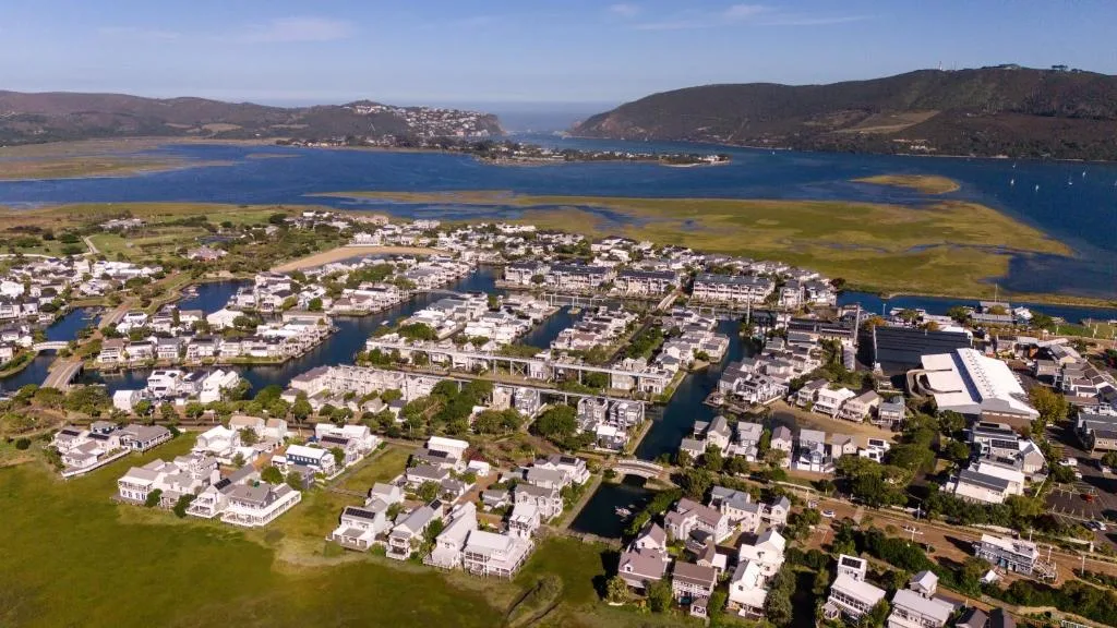 Aerial view of Thesen Island with lagoon, mountains, and coastal town landscape