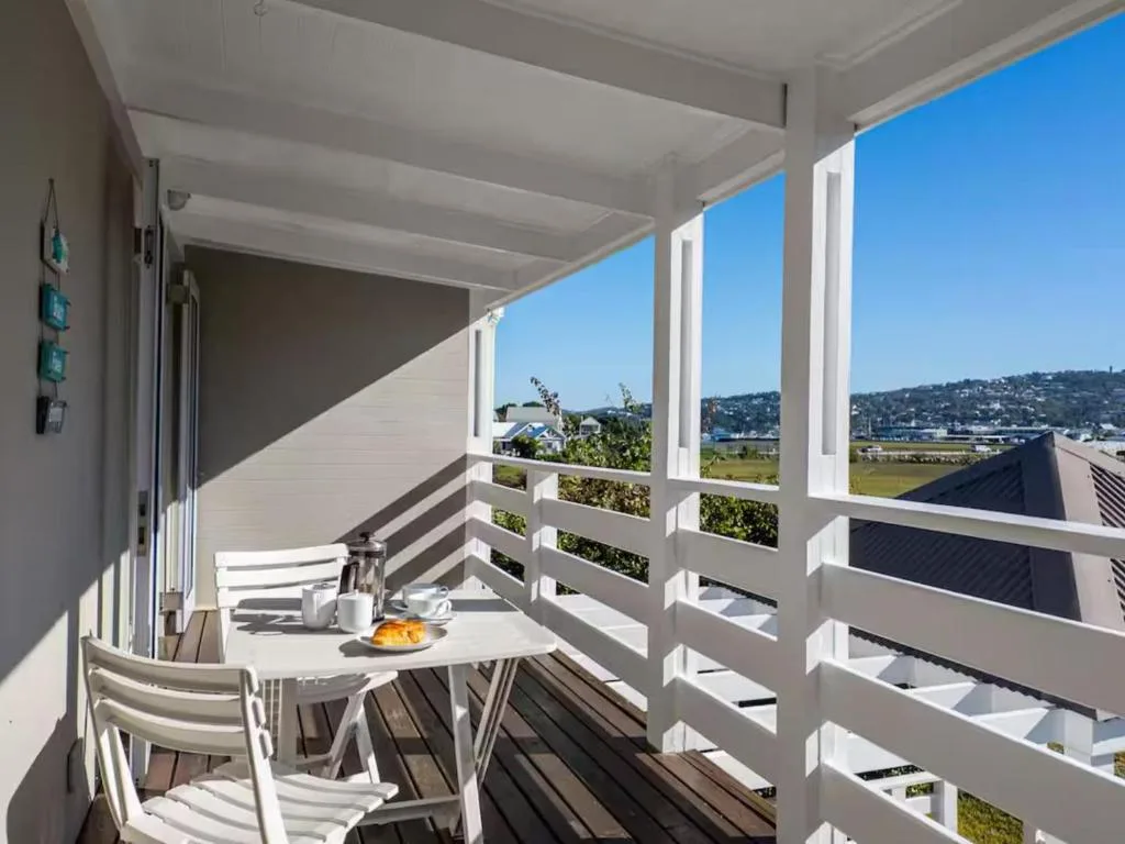 Covered deck with white railings overlooking Knysna lagoon and mountains