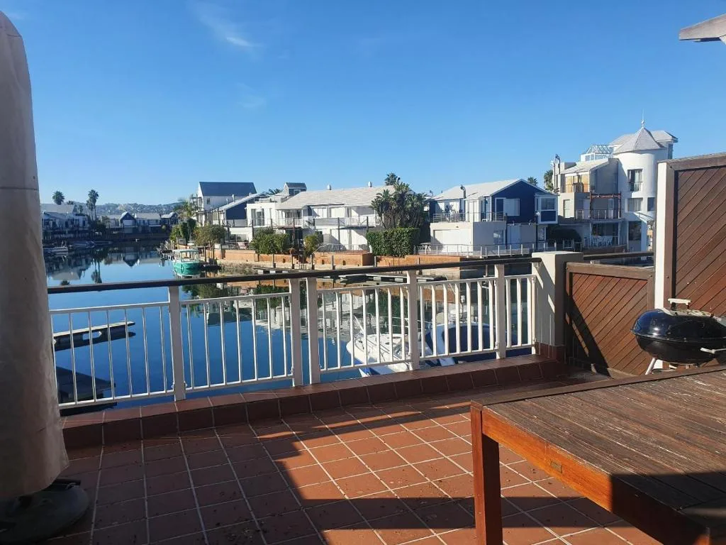 Waterfront deck with blue railing overlooking Knysna lagoon and boats