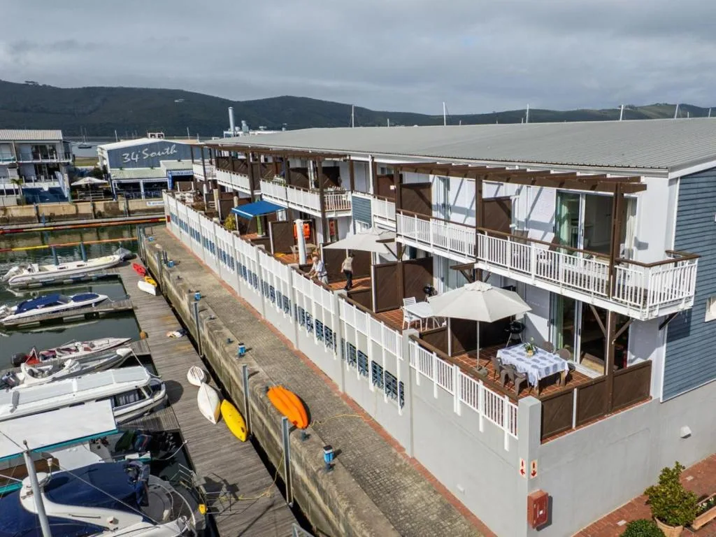 Waterfront accommodation building with multiple decks overlooking Knysna marina and boats