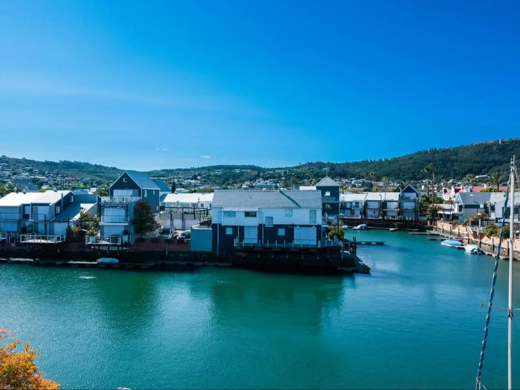 Turquoise lagoon with colorful waterfront buildings and forested hills