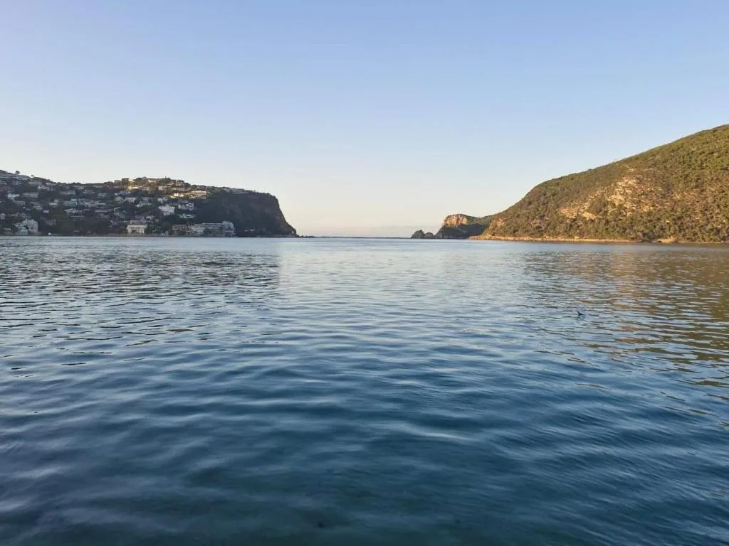 Scenic lagoon view with forested headlands and waterfront homes