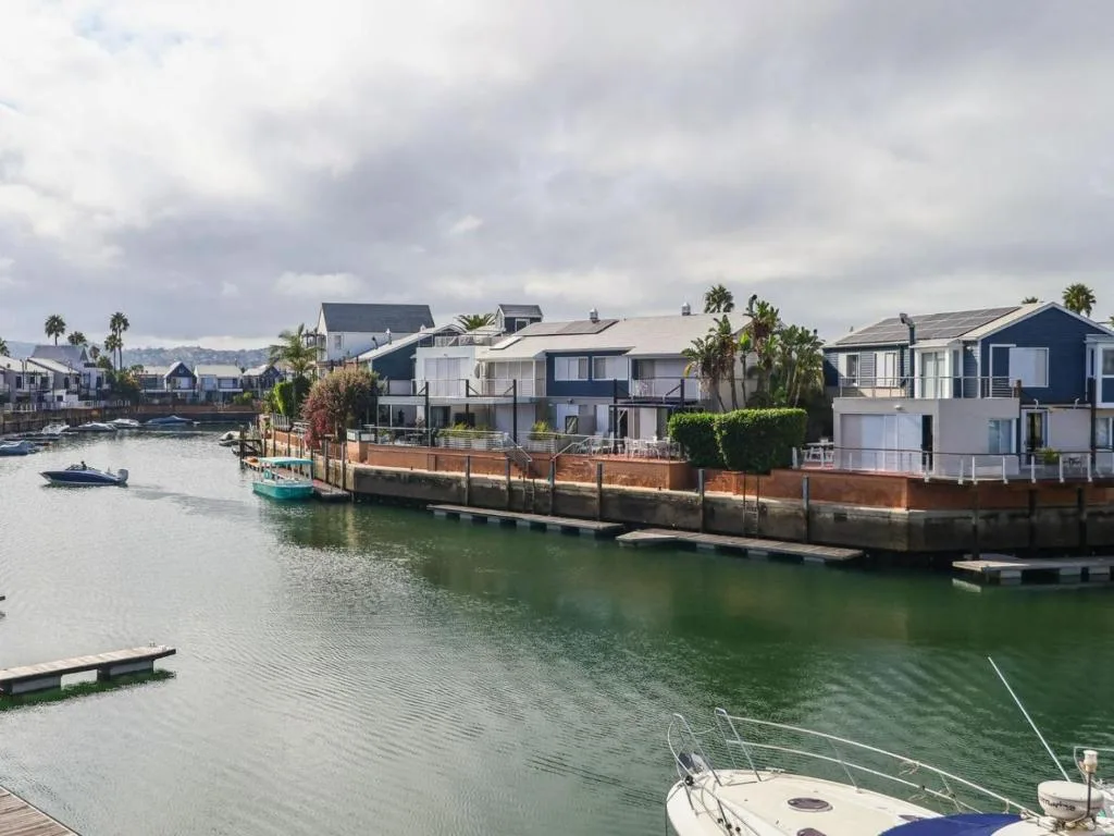 Waterfront homes along Knysna lagoon with boats and palm trees