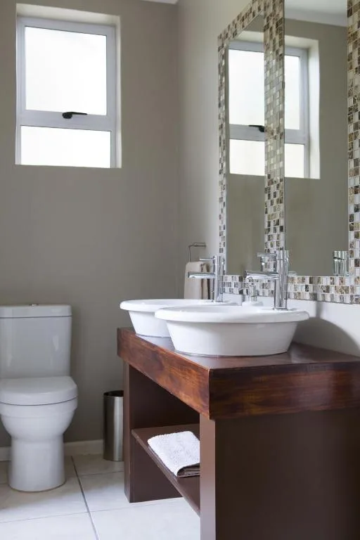 Modern bathroom with double vessel sinks and mosaic tile accents
