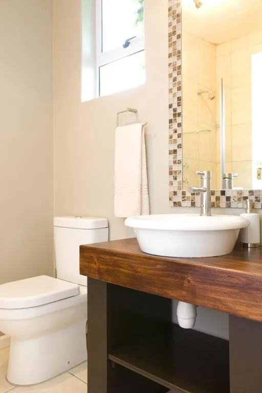 Modern bathroom with round vessel sink, wooden vanity, and contemporary fixtures
