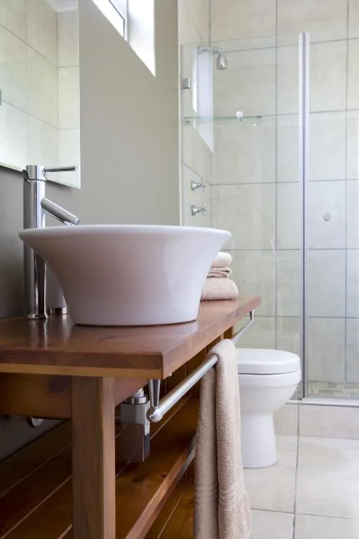 Modern bathroom with round white basin sink and glass shower enclosure
