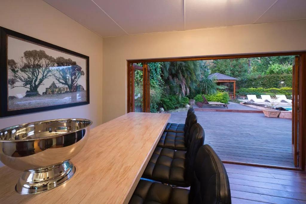 Modern lounge with wood counter, framed artwork, overlooking garden deck and loungers