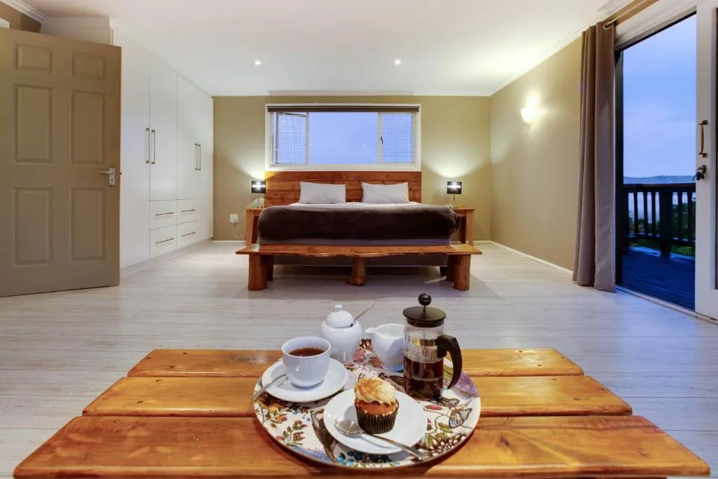 Spacious bedroom with wooden bed, wardrobe, and morning tea setup