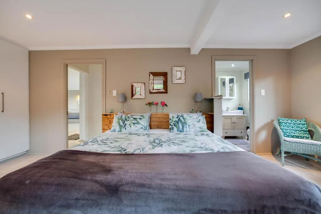 Spacious master bedroom with queen bed, en-suite bathroom, and garden views