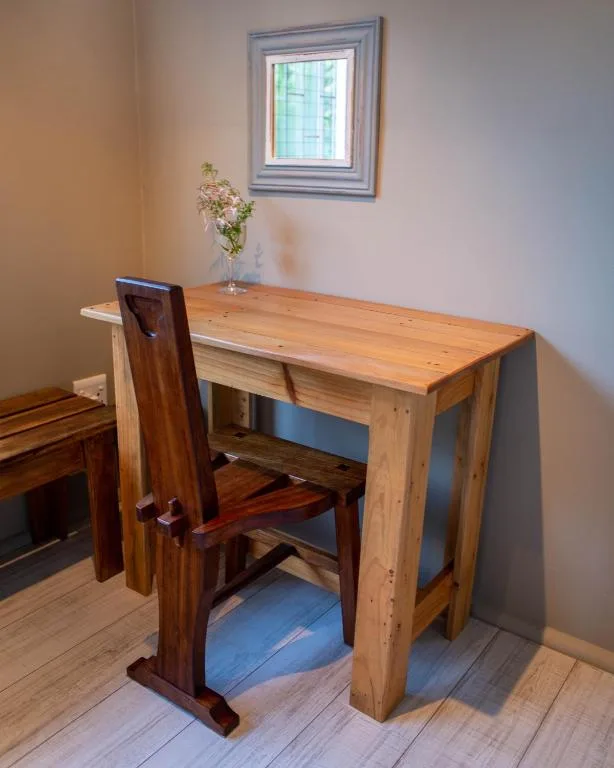 Wooden desk and chair with fresh flowers in bright room