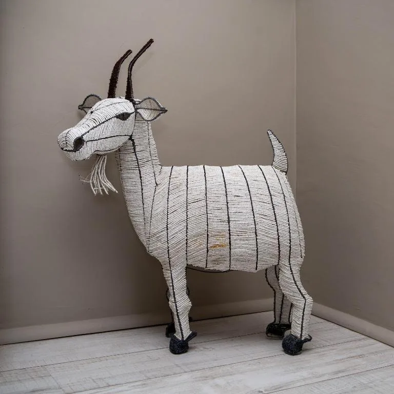 Decorative wire goat sculpture with curved horns and striped body