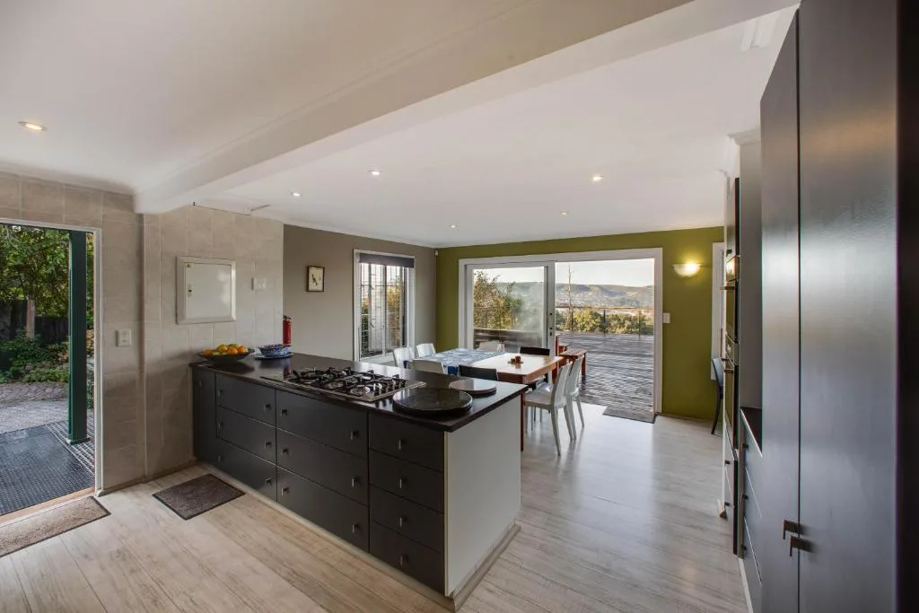 Modern open-plan kitchen with black island, stainless steel appliances, mountain views