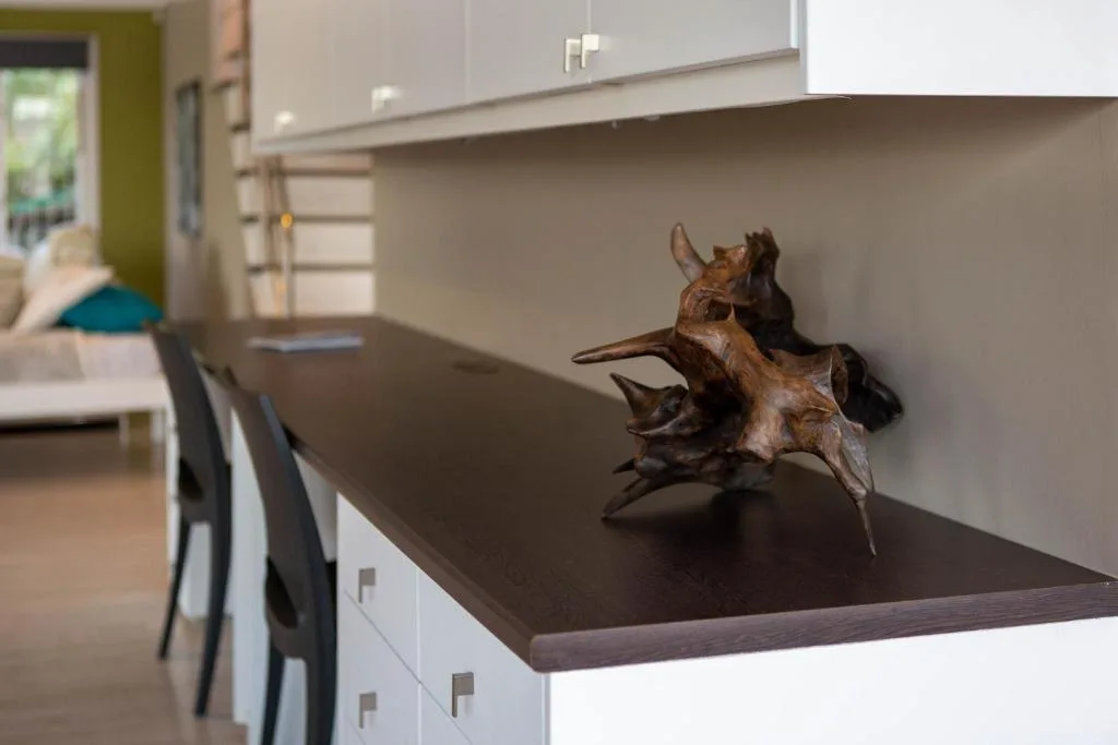 Modern kitchen counter with dark countertop and decorative wooden sculpture