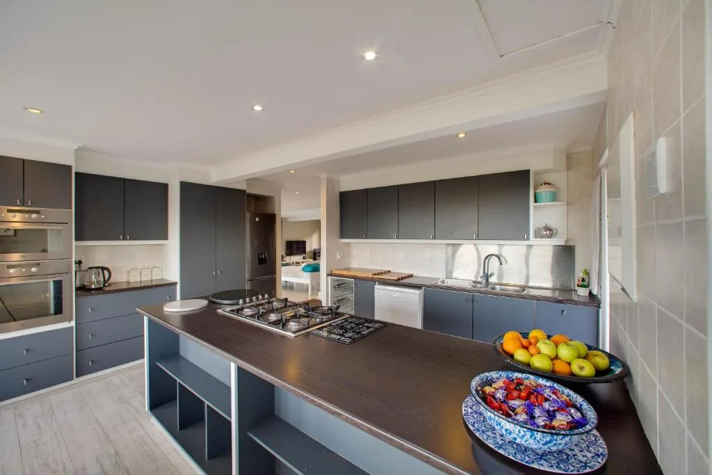 Modern kitchen with dark cabinetry, gas stovetop, and fresh fruit on island counter