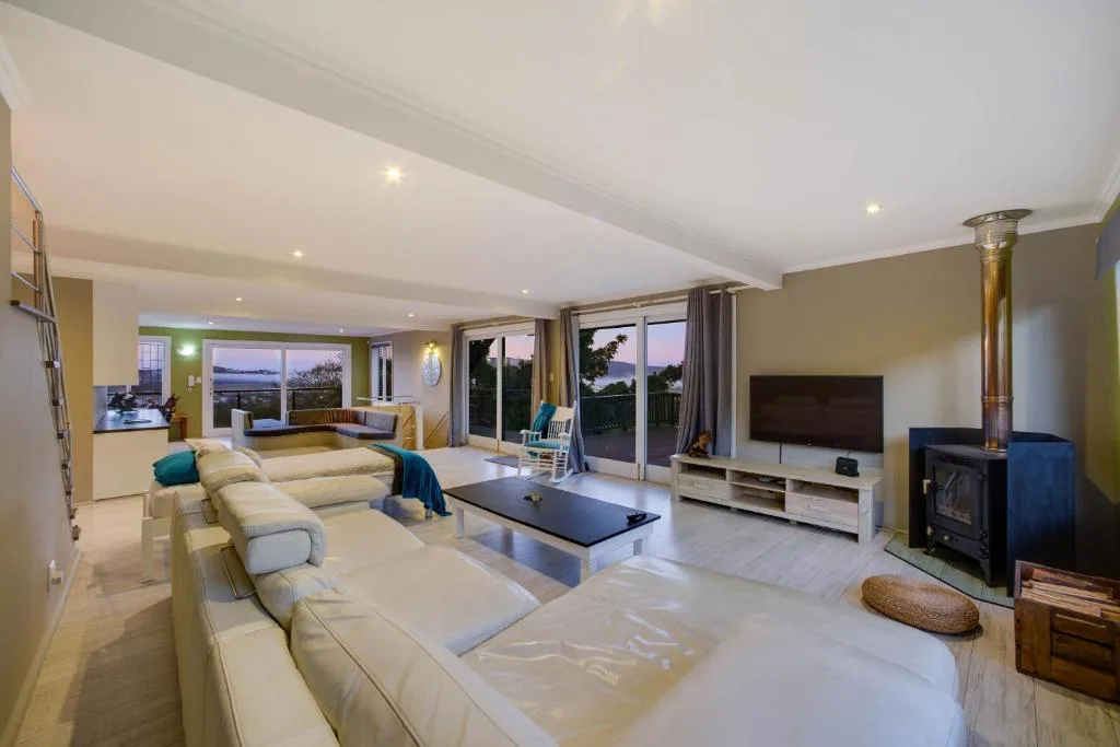 Spacious open-plan lounge with cream sofas and ocean views through large windows