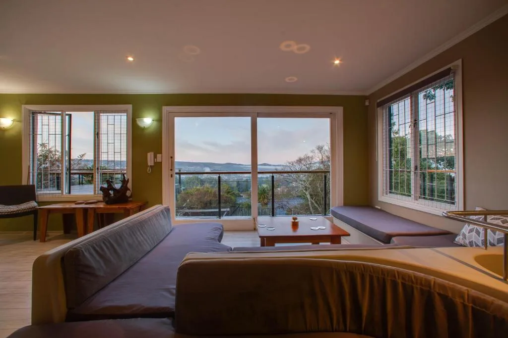 Modern lounge with sofas overlooking lagoon and mountains through large windows