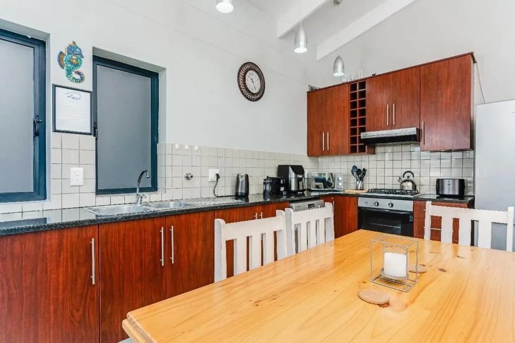 Modern kitchen with wooden cabinetry, stove, and dining table