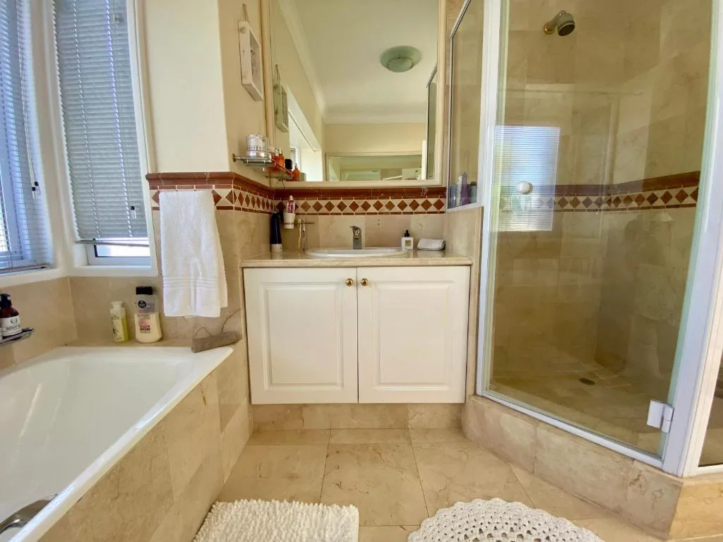 Spacious bathroom with soaking tub, walk-in shower, and elegant tile work