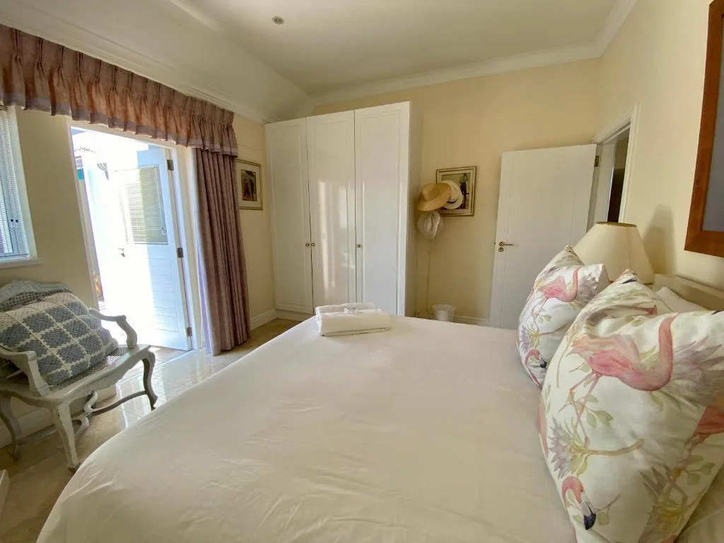 Bright bedroom with queen bed, built-in wardrobes, and patio doors