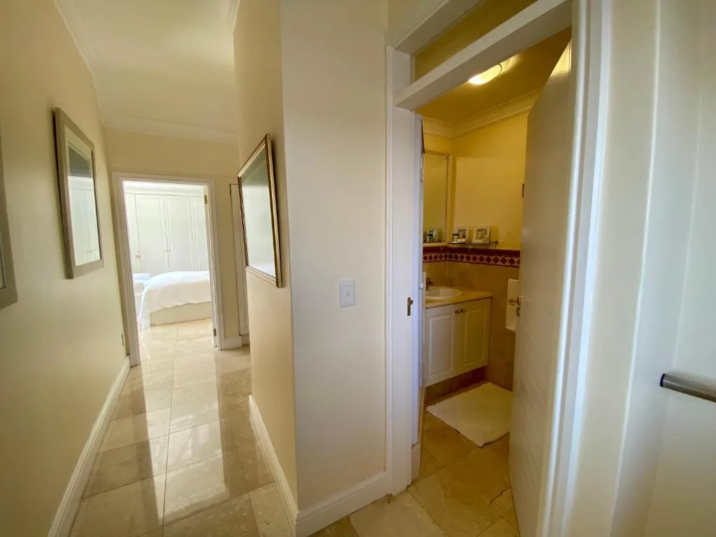 Modern hallway with bathroom entrance and bedroom view beyond
